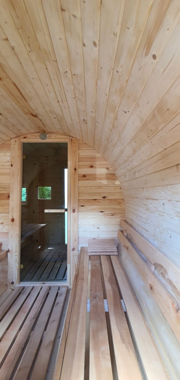 Fasssauna Innenraum mit Sicht auf die Glastür in den Vorraum